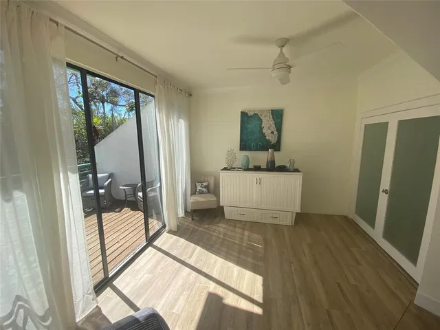 a living room with a bed furniture and a large window