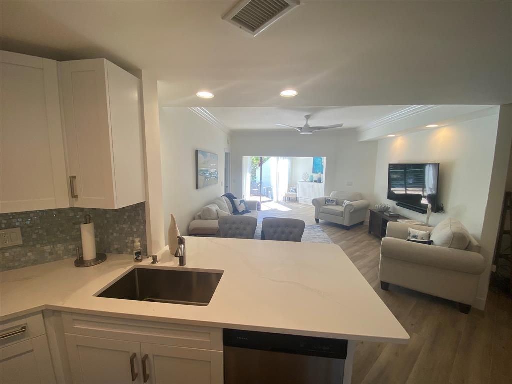 2286 Anchorage Lane, Unit A Naples, FL 34104 - Photo 9 of 41 a kitchen with a refrigerator a sink and white cabinets