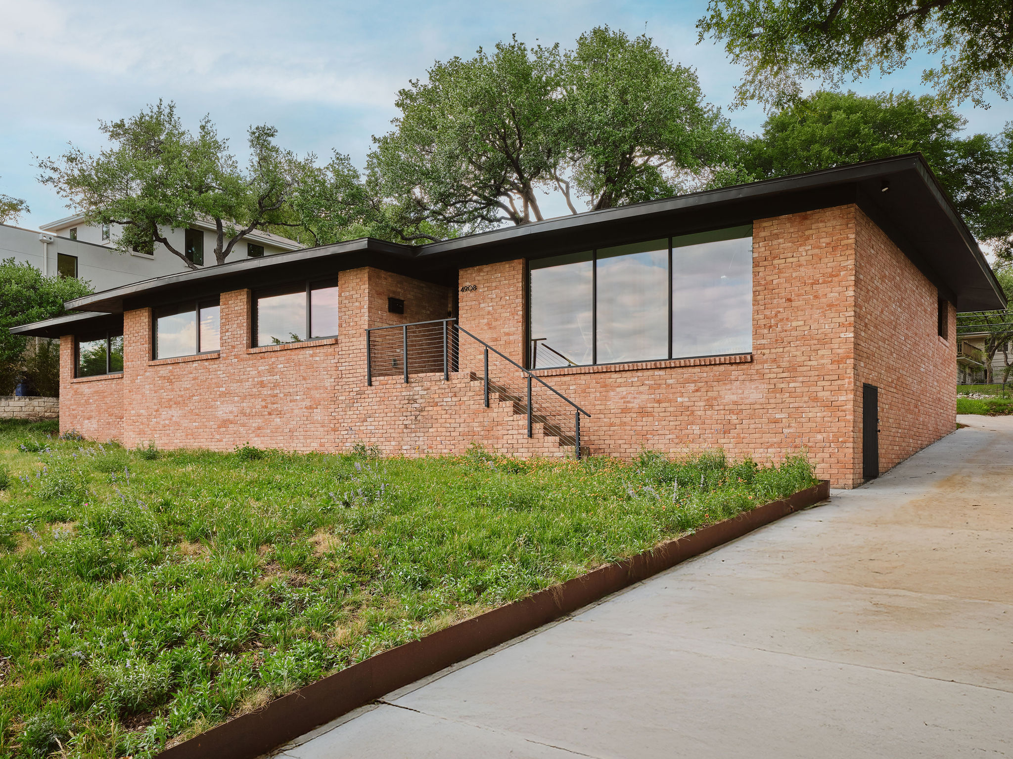 Undisclosed Address Austin, TX 78731 - Photo 7 of 26 A striking brick facade with large windows defines this contemporary residence.