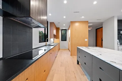 a bathroom with a sink and mirror with bathtub
