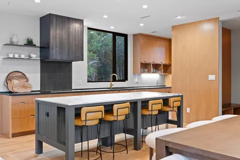 a kitchen with a sink a refrigerator and wooden floor