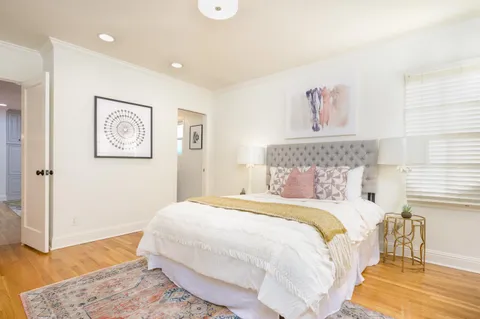 a bedroom with a bed and a painting on the wall