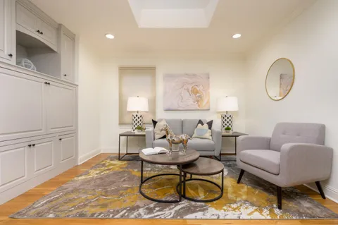 a living room with furniture a rug kitchen view and a fireplace