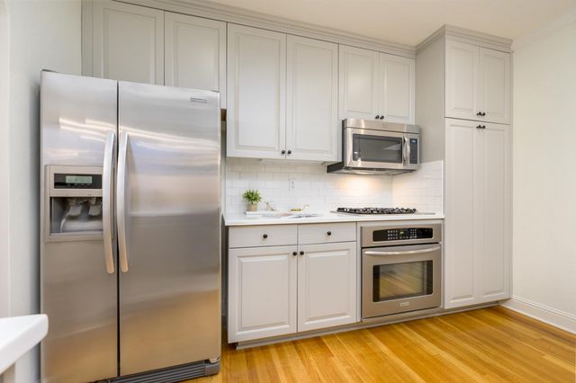 a kitchen with stainless steel appliances granite countertop a refrigerator and a stove top oven