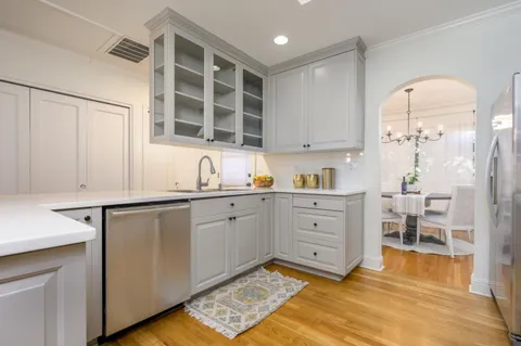 a kitchen with white cabinets and window