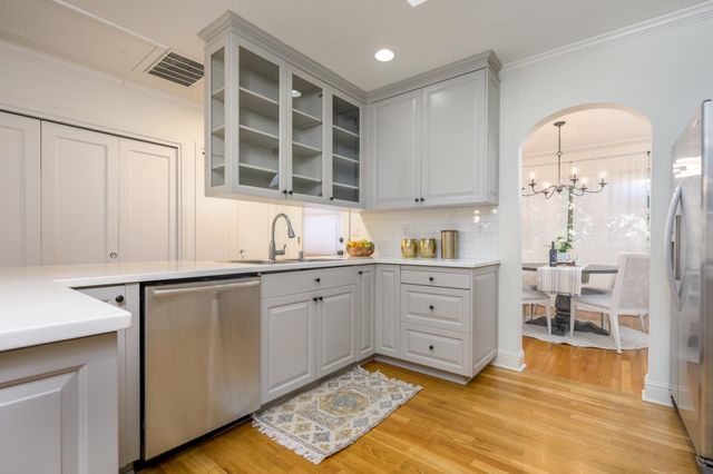 a kitchen with white cabinets and window