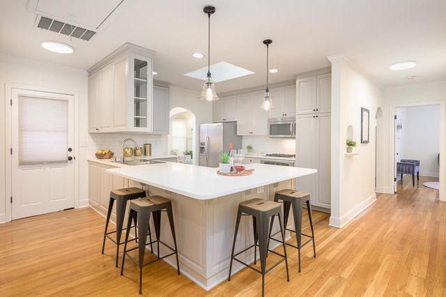 a kitchen with kitchen island a stove a table and chairs in it