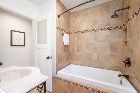 a bathroom with a bath tub a shower and a sink