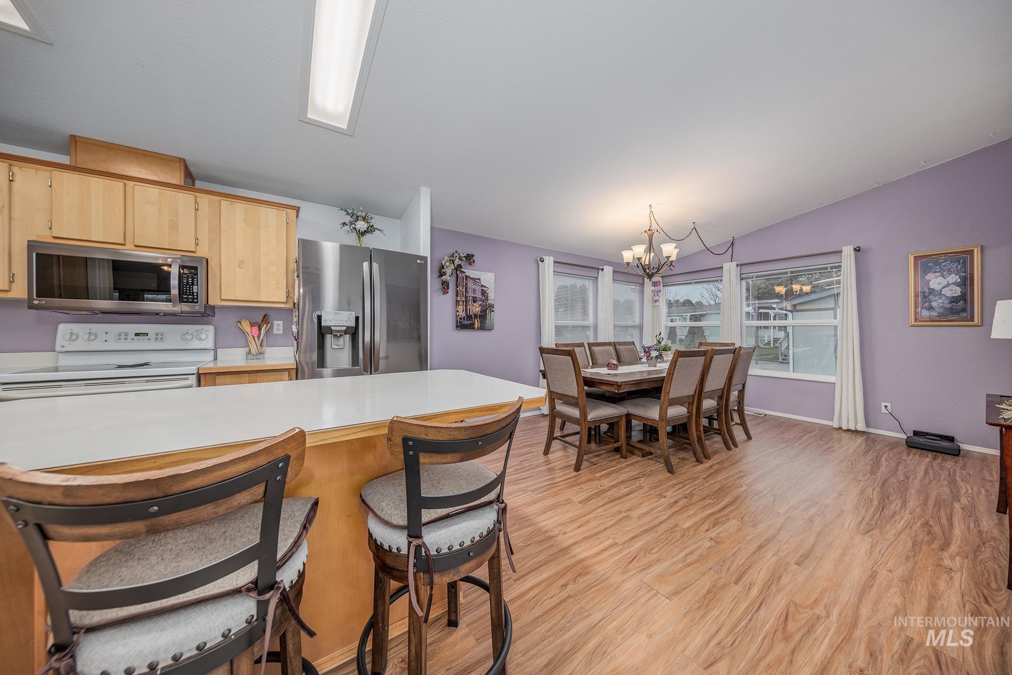 2750 Alden Road, Unit 27 Fruitland, ID 83619 - Photo 16 of 45 Kitchen featuring light countertops, appliances with stainless steel finishes, light wood-style floors, a chandelier, and a breakfast bar area