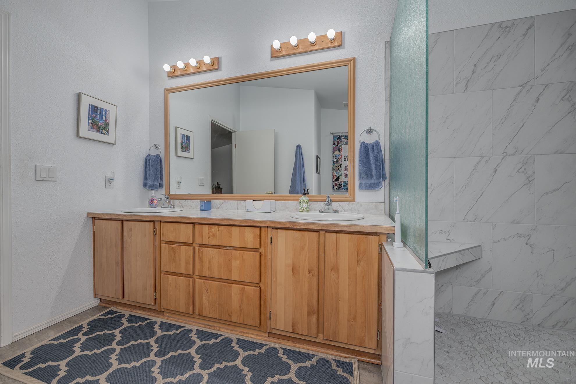 2750 Alden Road, Unit 27 Fruitland, ID 83619 - Photo 22 of 45 Full bathroom with double vanity, a marble finish shower, and a textured wall