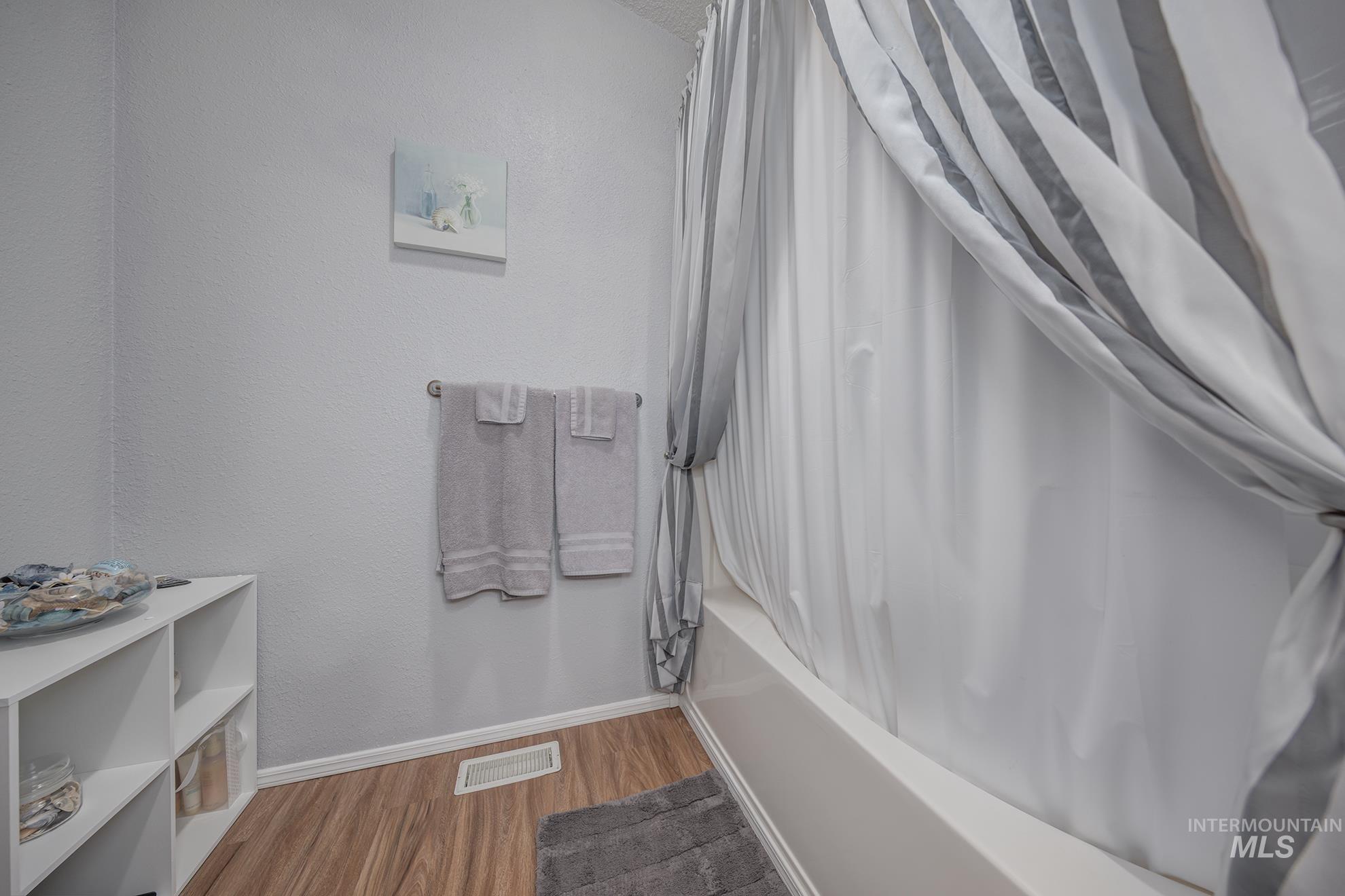 2750 Alden Road, Unit 27 Fruitland, ID 83619 - Photo 29 of 45 Full bathroom featuring shower / tub combo with curtain, wood finished floors, and a textured wall