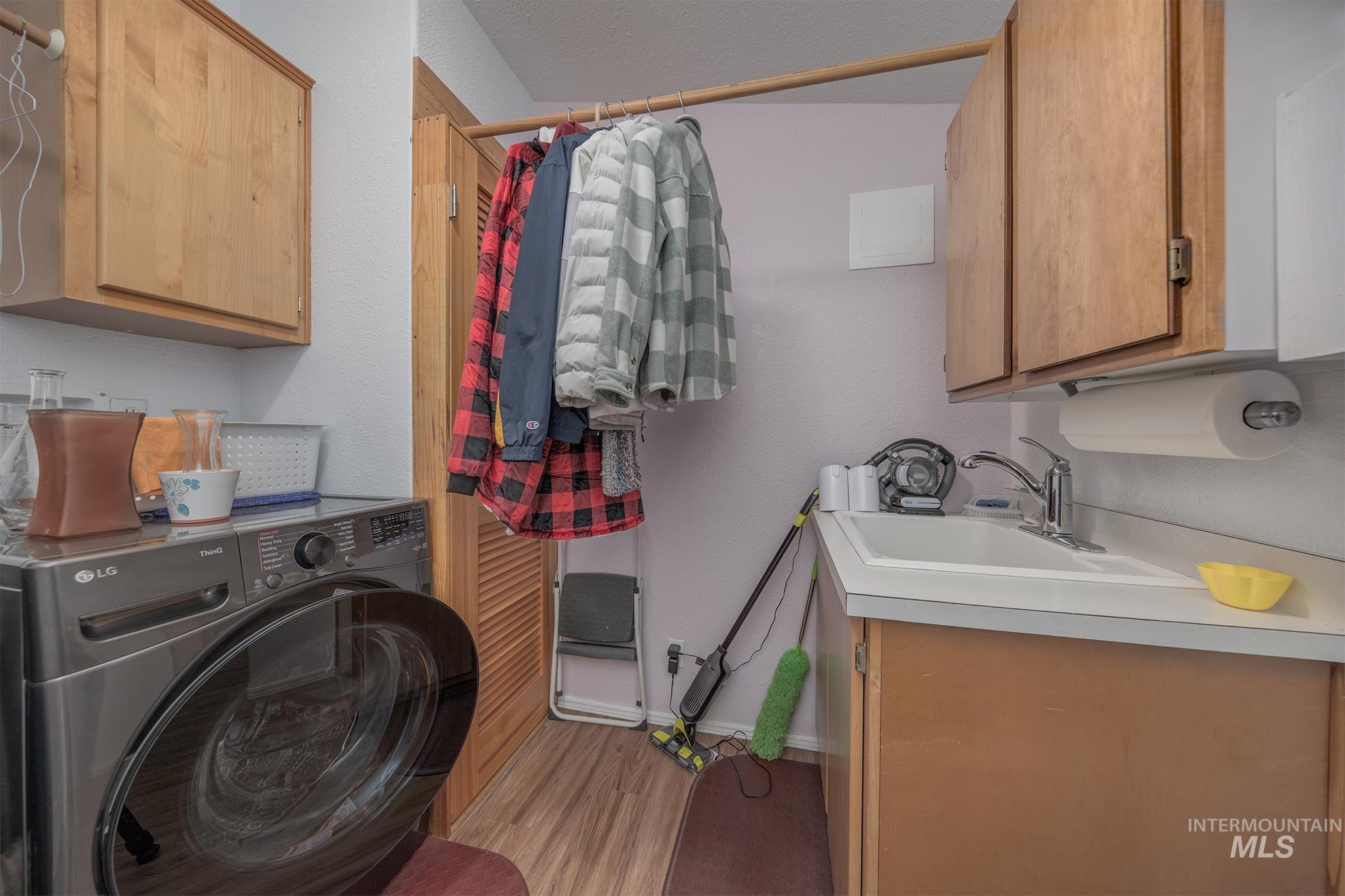 2750 Alden Road, Unit 27 Fruitland, ID 83619 - Photo 31 of 45 Laundry area featuring cabinet space, washer / clothes dryer, light wood-style flooring, a textured wall, and a textured ceiling