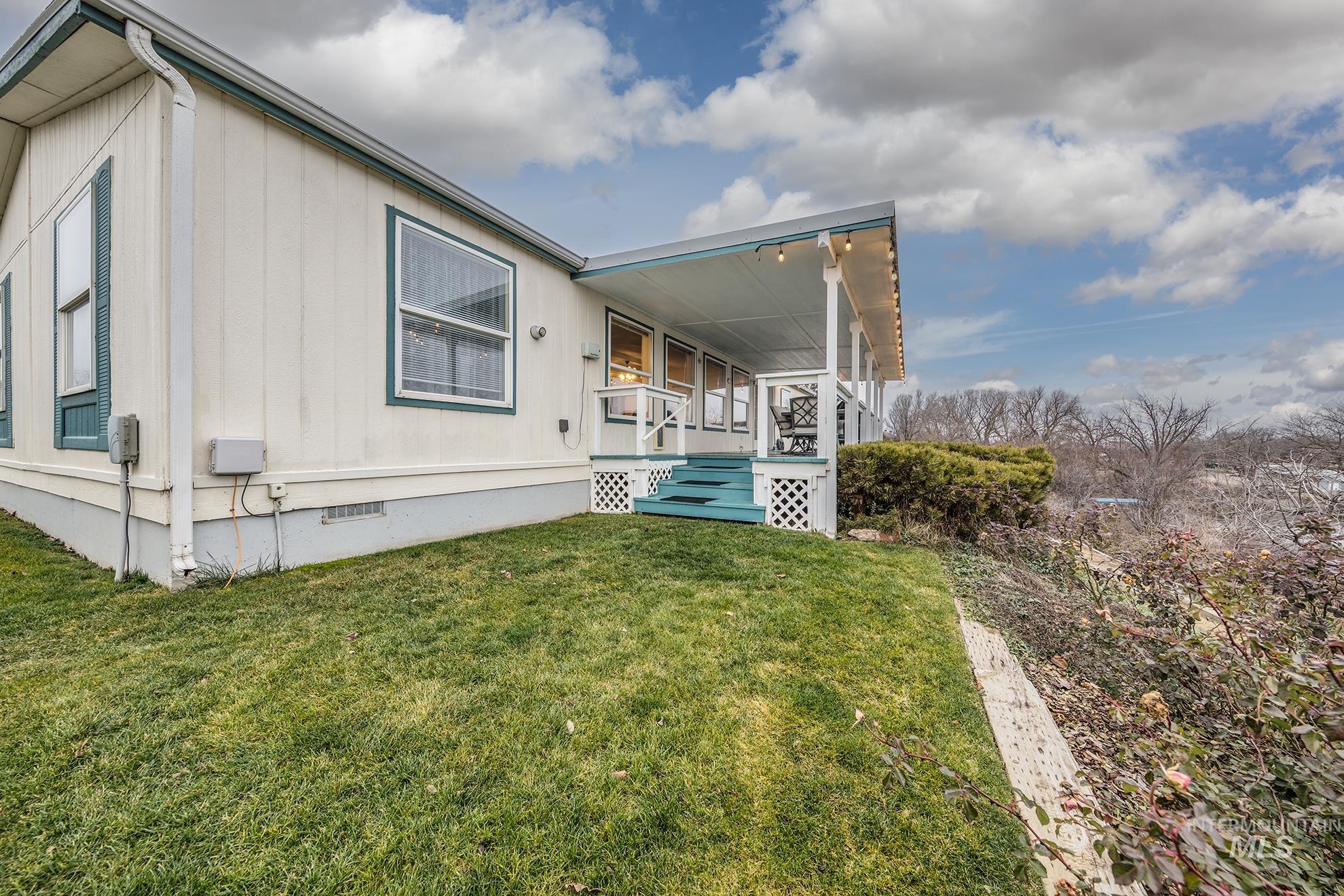 2750 Alden Road, Unit 27 Fruitland, ID 83619 - Photo 34 of 45 View of property exterior featuring crawl space, a lawn, and a porch