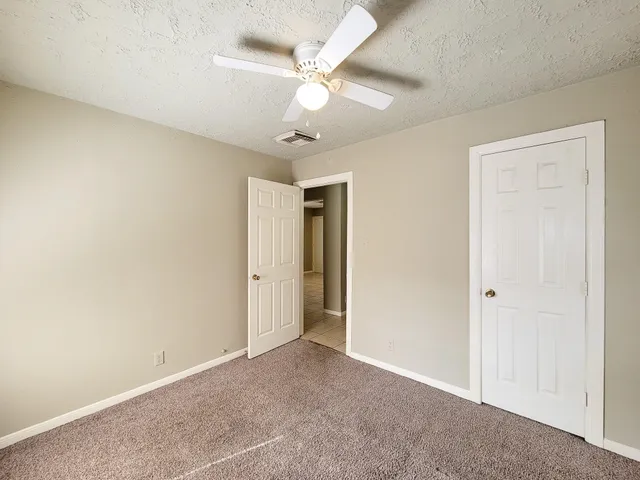 an empty room with a ceiling fan and a window