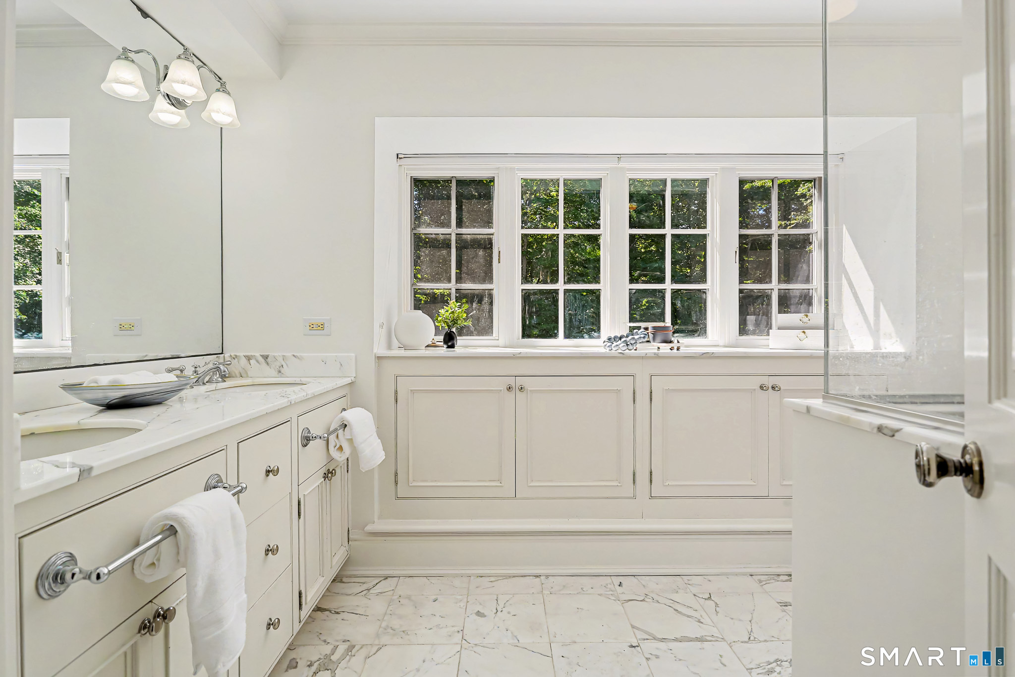 6 Adams Way Weston, CT 06883 - Photo 22 of 40 The primary bathroom is very zen, with a marble floor, great built-ins below the windows, and dual sink vanity.