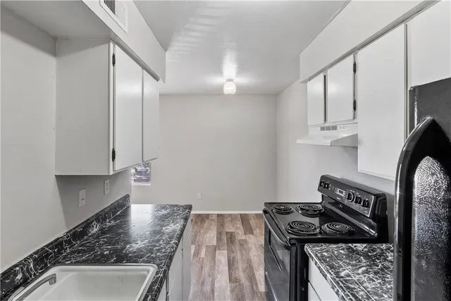 a kitchen with granite countertop a stove and a sink