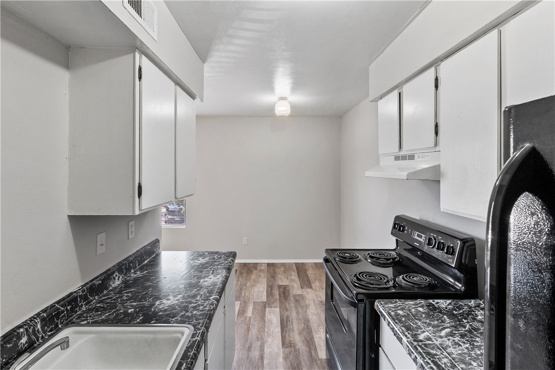2808 Cypress Bend Circle, Unit A Bryan, TX 77801 - Photo 11 of 15 a kitchen with granite countertop a stove and a sink
