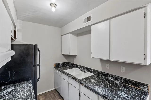 a kitchen with a refrigerator and a stove top oven
