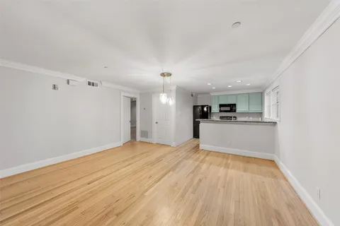 a view of empty room with wooden floor and window
