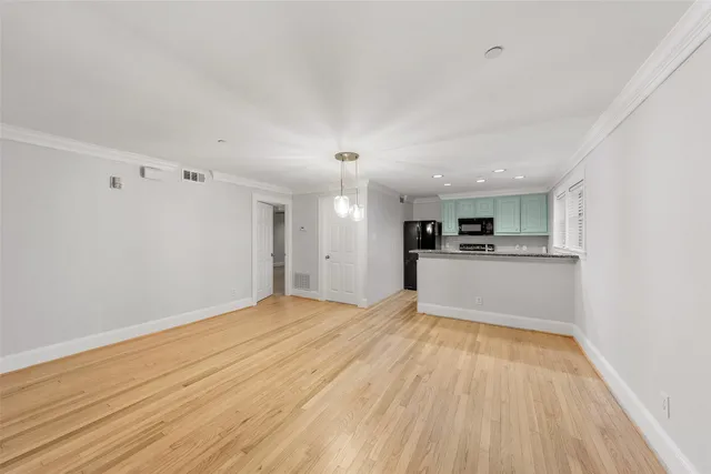 a view of empty room with wooden floor and window