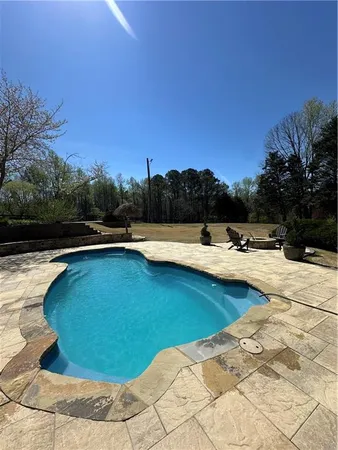 a view of swimming pool with outdoor seating and yard in back