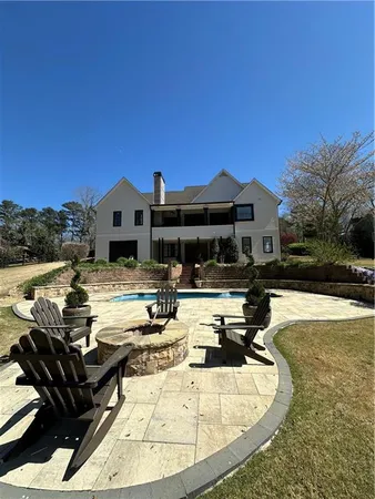 a view of a house with swimming pool and sitting area