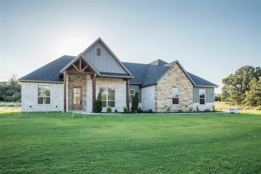141 Prairie Winds Drive Poolville, TX 76487 - Photo 1 of 15 a front view of a house with a yard and garage