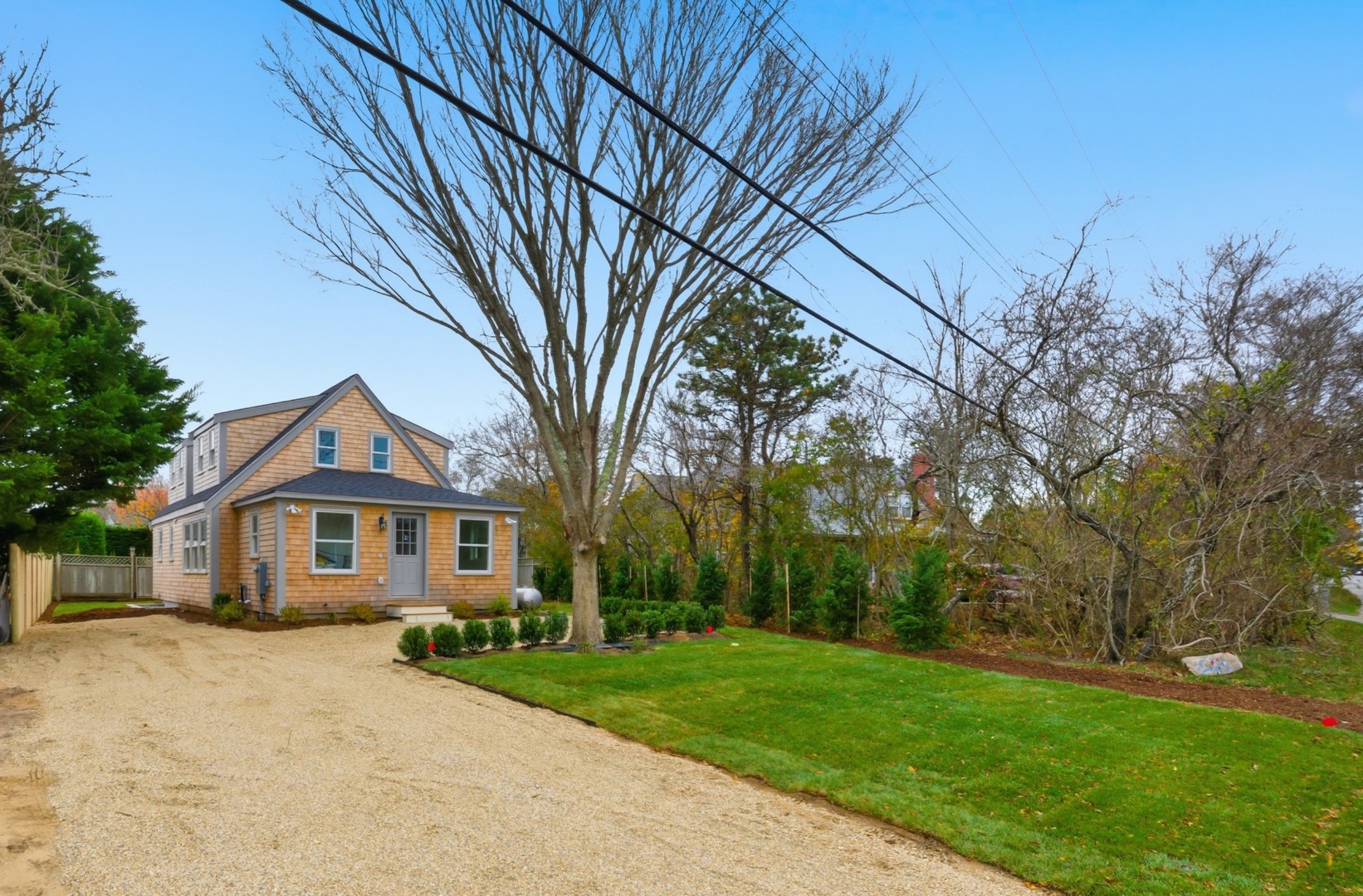 38 Hooper Farm Road Nantucket, MA 02554 - Photo 3 of 19 a front view of a house with a garden and trees