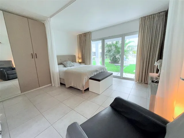 a room with a bed and large windows