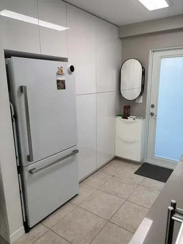 a utility room with mirror and a washer dryer