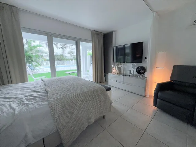 a bedroom with a bed and large window