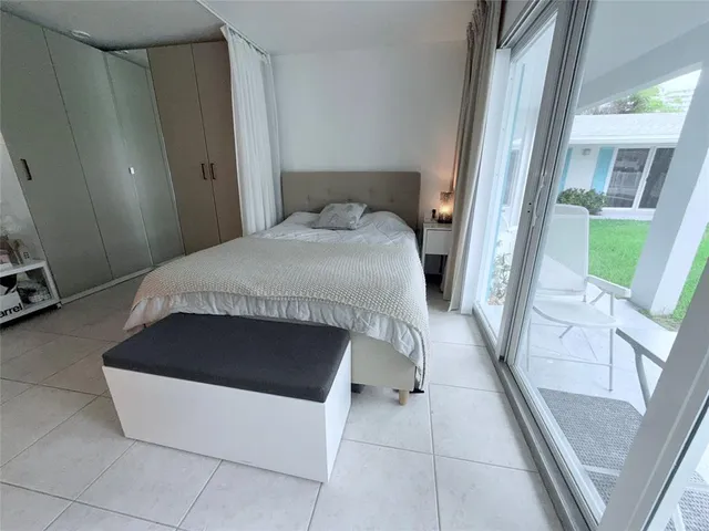 a bedroom with a bed and a large window