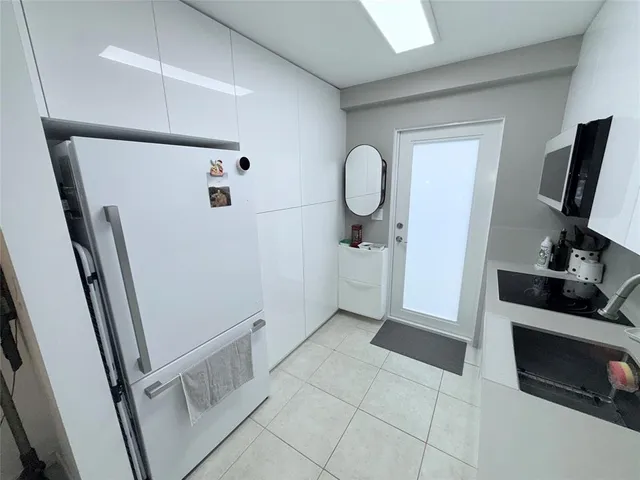 a view of a refrigerator in kitchen and utility room