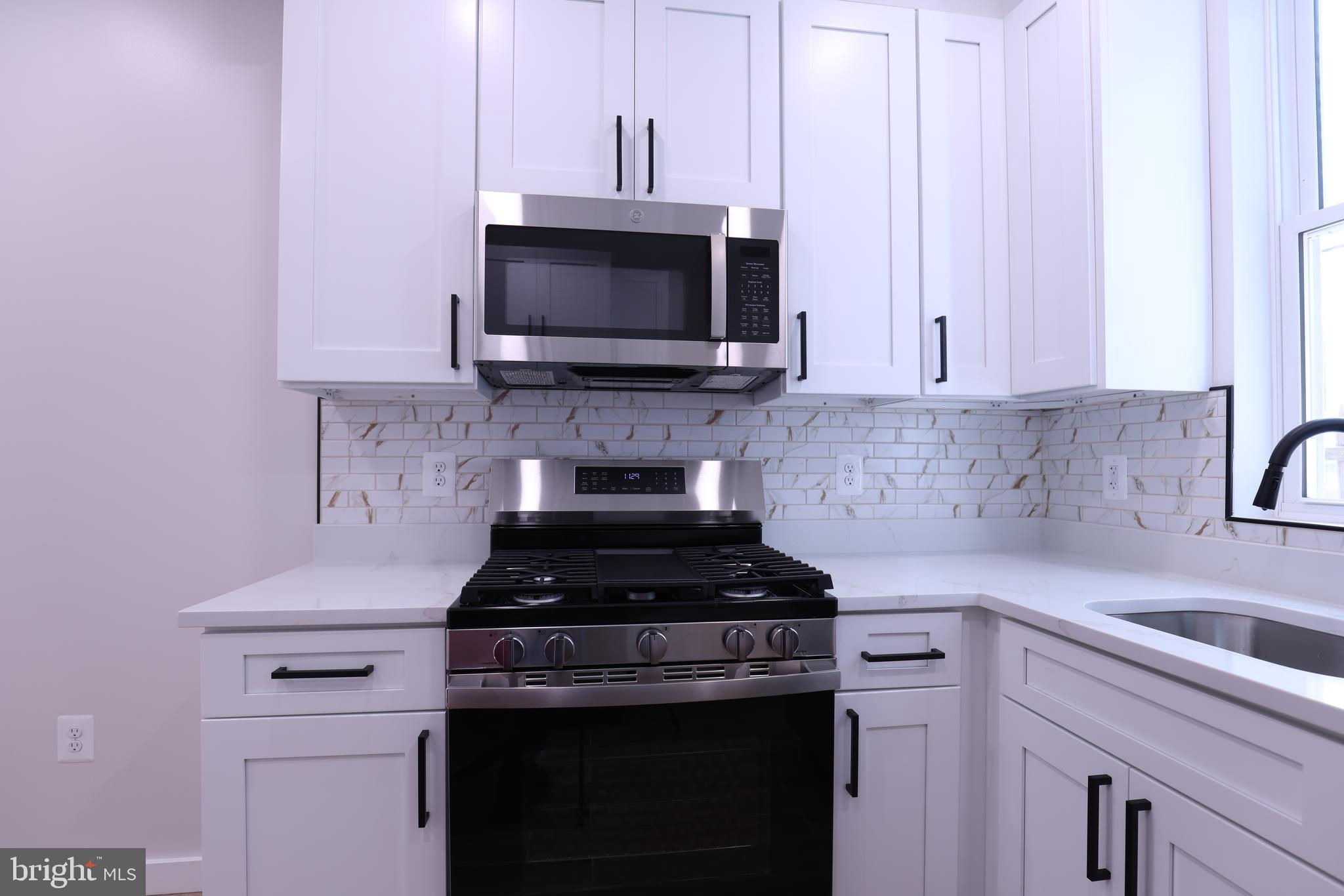 2039 Rosedale Street Northeast Washington, DC 20002 - Photo 4 of 18 a kitchen with microwave cabinets and stove top oven