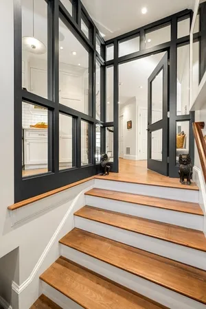 a view of staircase with two windows and a chandelier