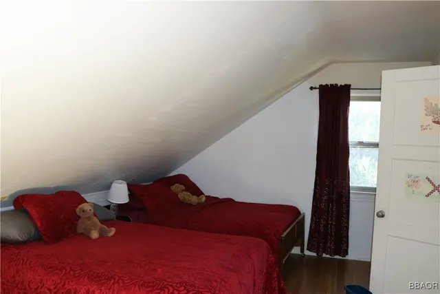 a bedroom with a bed and a lamp next to a window