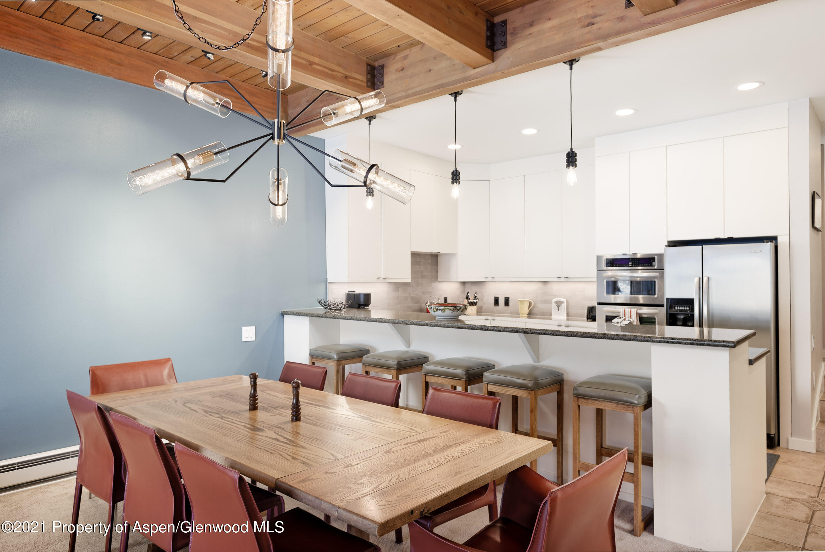 810 Ridge Road, Unit 2 Snowmass Village, CO 81615 - Photo 5 of 31 a kitchen with stainless steel appliances granite countertop a kitchen island a stove a table and chairs