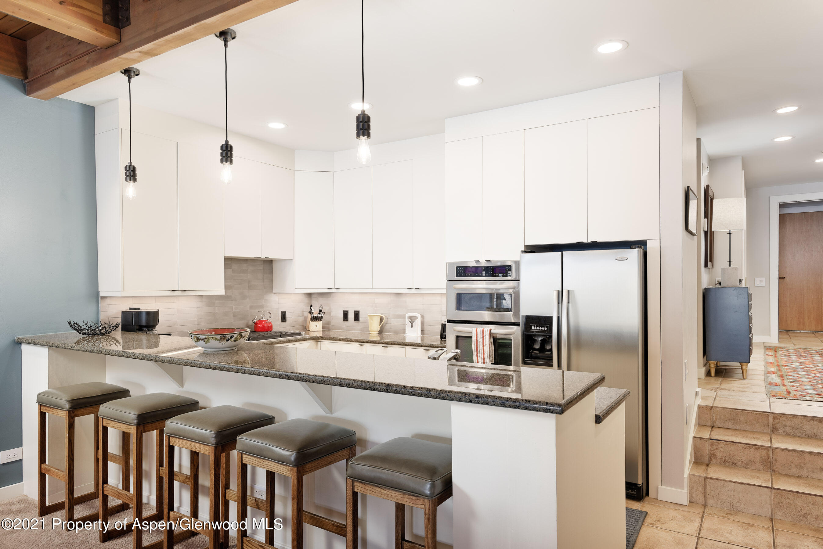 810 Ridge Road, Unit 2 Snowmass Village, CO 81615 - Photo 6 of 31 a kitchen with stainless steel appliances granite countertop a sink refrigerator and cabinets