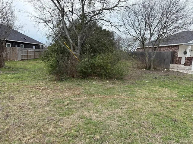 a view of a yard in front of a house with large tree