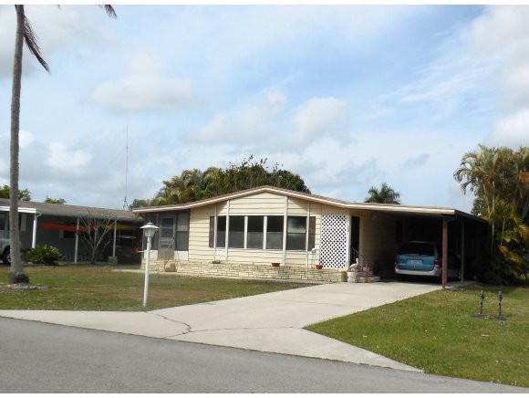 120 Audubon Road Naples, FL 34114 - Photo 1 of 11 a front view of a house with a garden