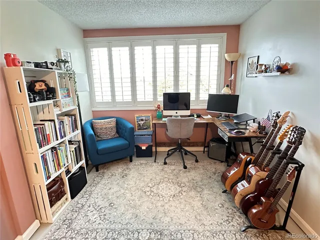a view of a livingroom with workspace and a window
