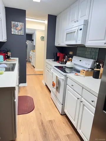 a kitchen with white cabinets and white appliances