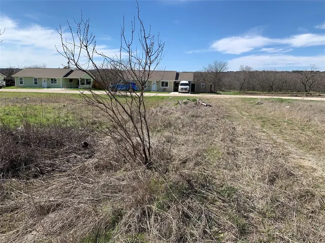 a view of a yard with wooden fence