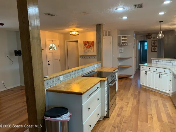 a room with stainless steel appliances kitchen island a table and chairs in it