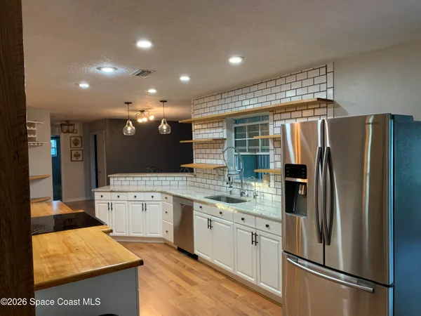 a kitchen with stainless steel appliances granite countertop a refrigerator and a sink