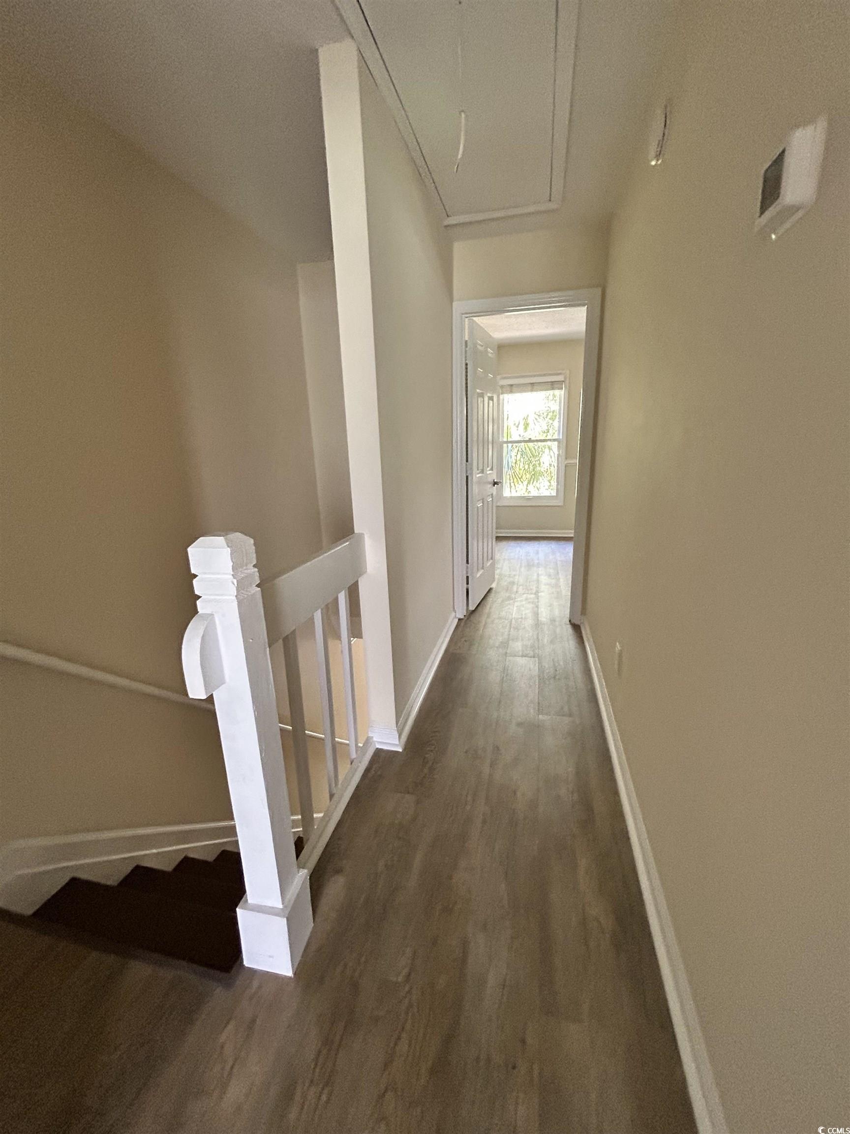 306 76th Avenue North, Unit B2 Myrtle Beach, SC 29572 - Photo 5 of 6 Hall featuring dark wood finished floors, an upstairs landing, and attic access