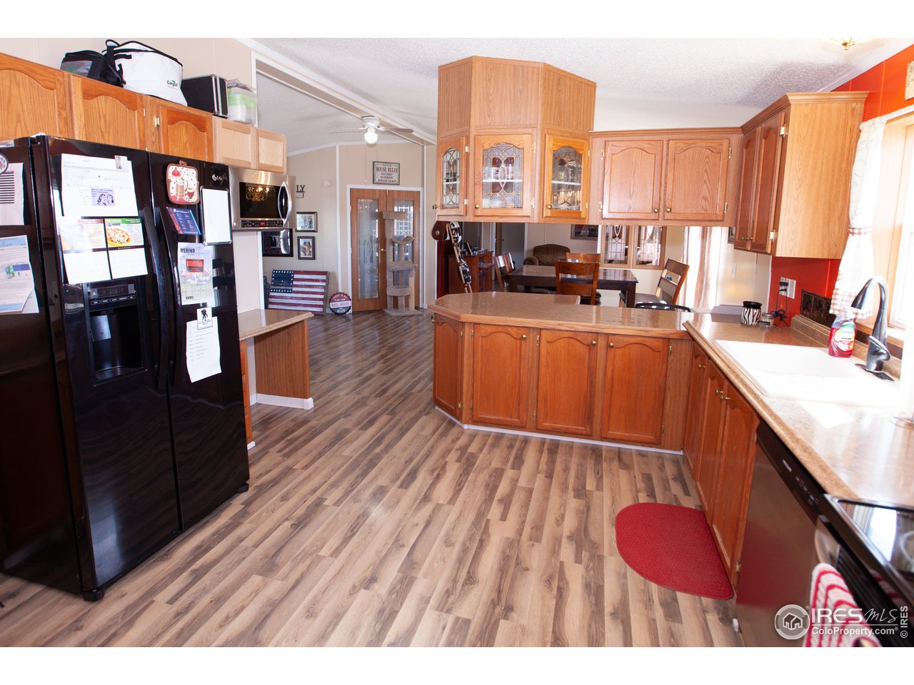 14780 Bluestem Street Sterling, CO 80751 - Photo 11 of 40 a open kitchen with stainless steel appliances granite countertop a stove top oven a sink dishwasher and cabinets with wooden floor