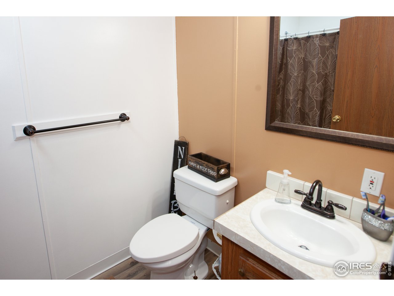 14780 Bluestem Street Sterling, CO 80751 - Photo 29 of 40 a bathroom with a toilet sink and mirror
