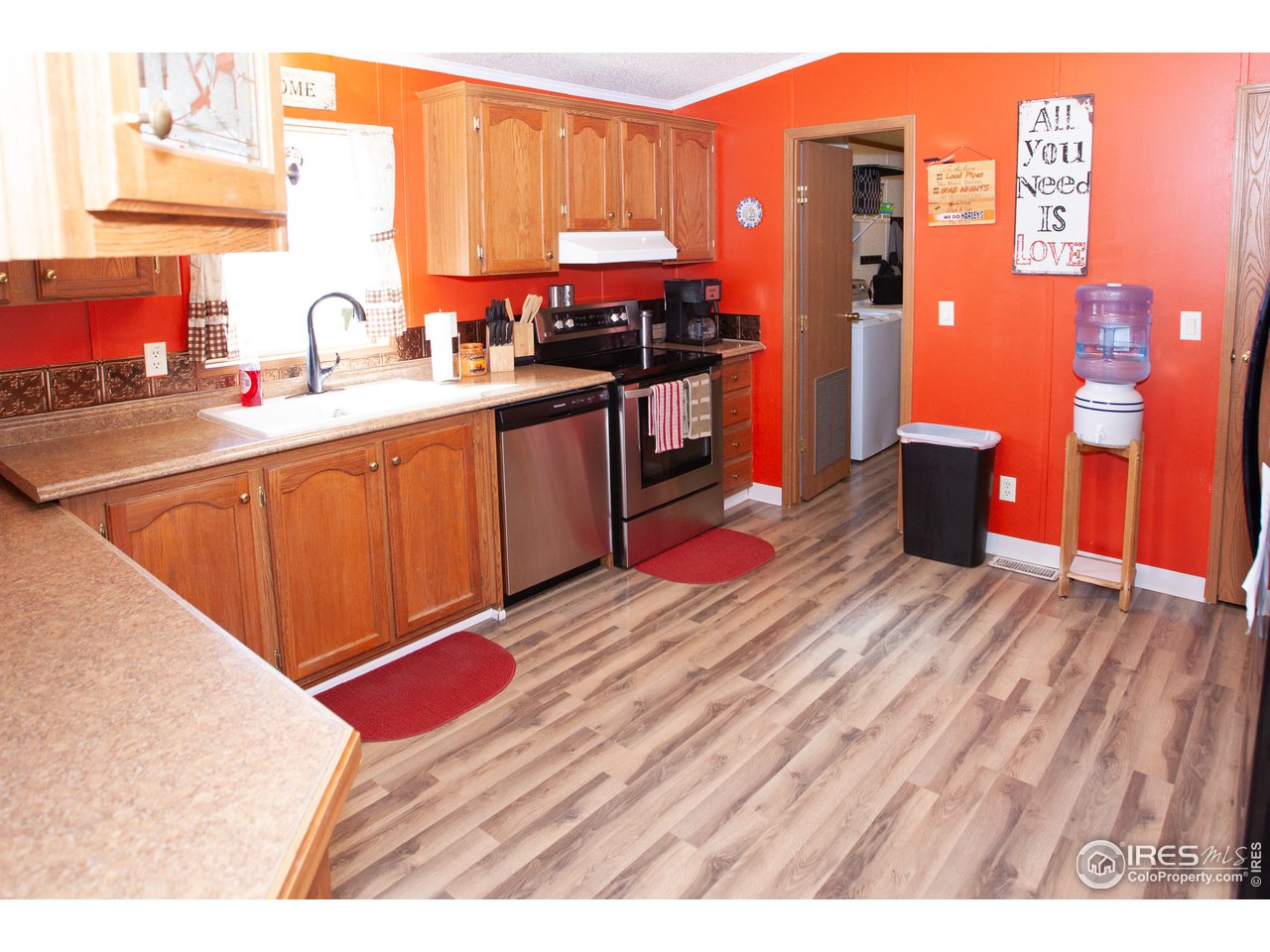 14780 Bluestem Street Sterling, CO 80751 - Photo 9 of 40 a kitchen with stainless steel appliances kitchen island granite countertop a sink dishwasher stove and cabinets