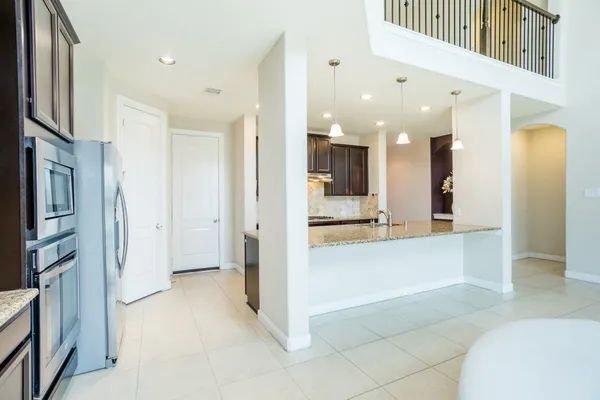 a kitchen with granite countertop stainless steel appliances a sink stove top oven and cabinets